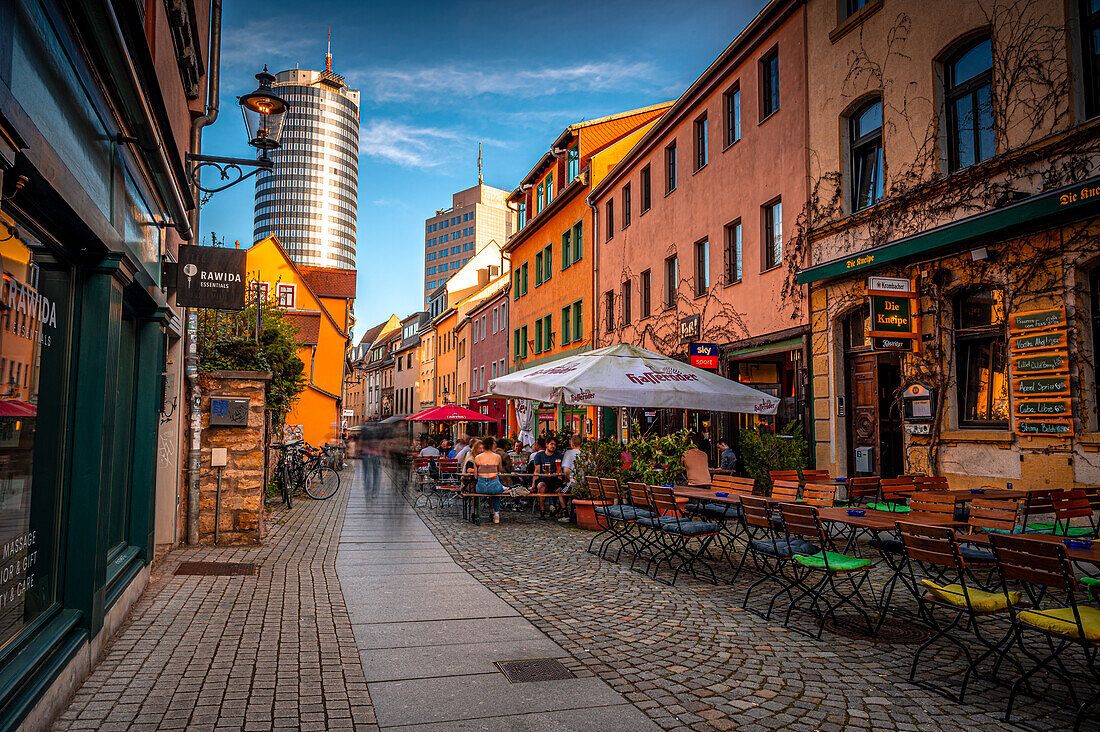 Die Restaurant Straße Wagnergasse mit dem Jentower im Hintergrund bei Sonnenuntergang und blauem Himmel, Jena, Thüringen, Deutschland