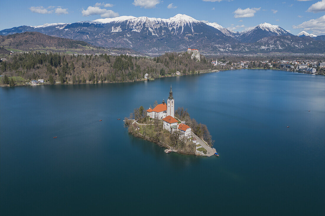  Aerial view of St. Mary&#39;s Church in Lake Bled and snowy mountains in Bled, Slovenia, Europe. 