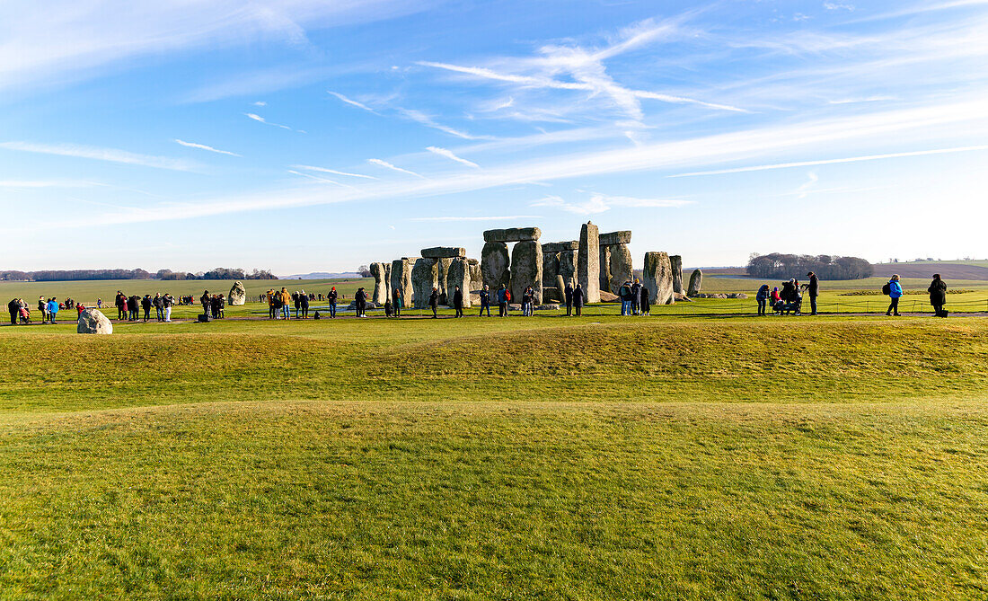 Tourists view standing stones of Neolithic henge, Stonehenge, Wiltshire, England, UK