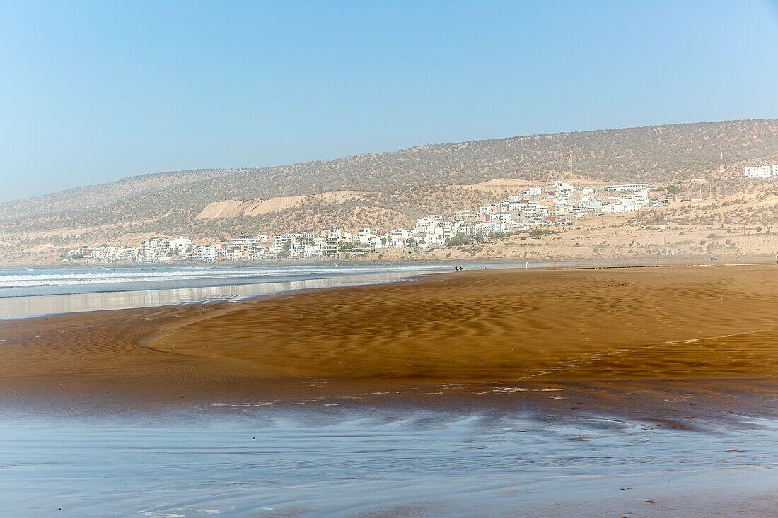 Sandy beach at low tide near village of Taghazout, Morocco, North Africa