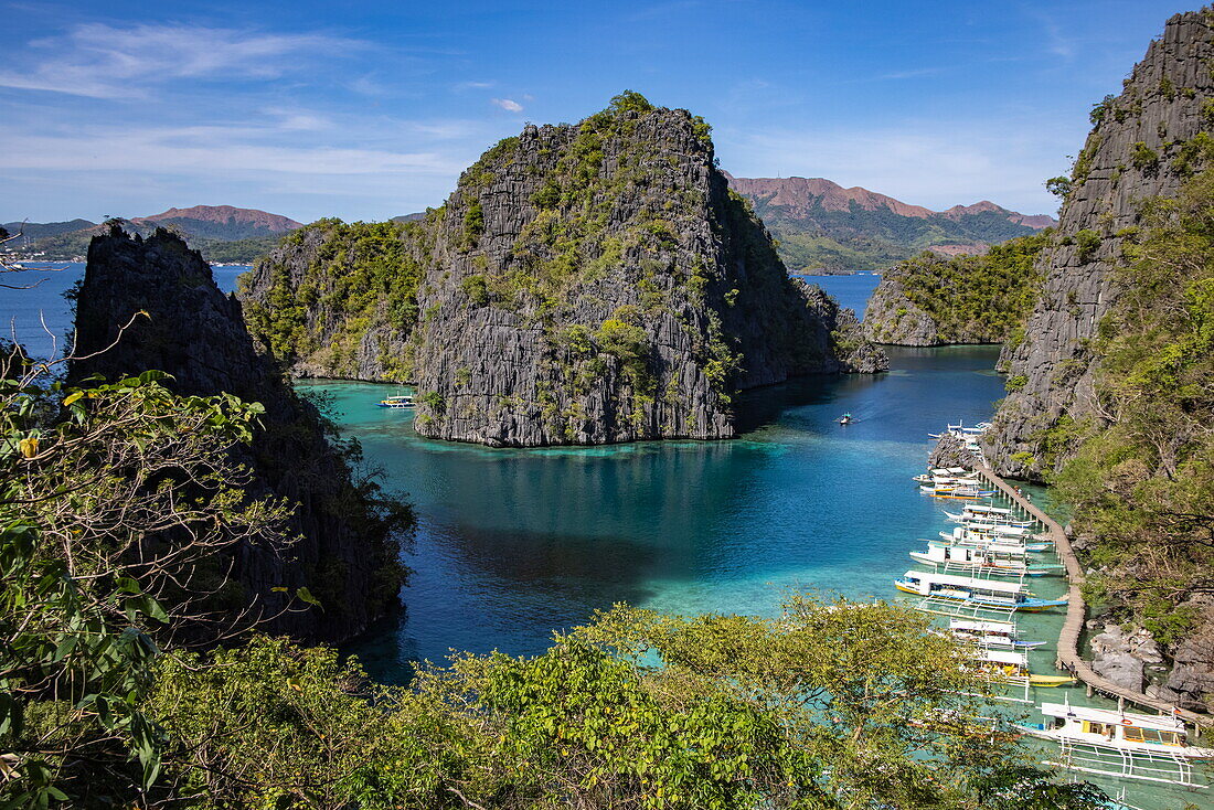  View of Bangka outrigger canoe tour boats moored in the lagoon, seen from the observation deck en route to Kayangan Lake, Coron, Palawan, Philippines 