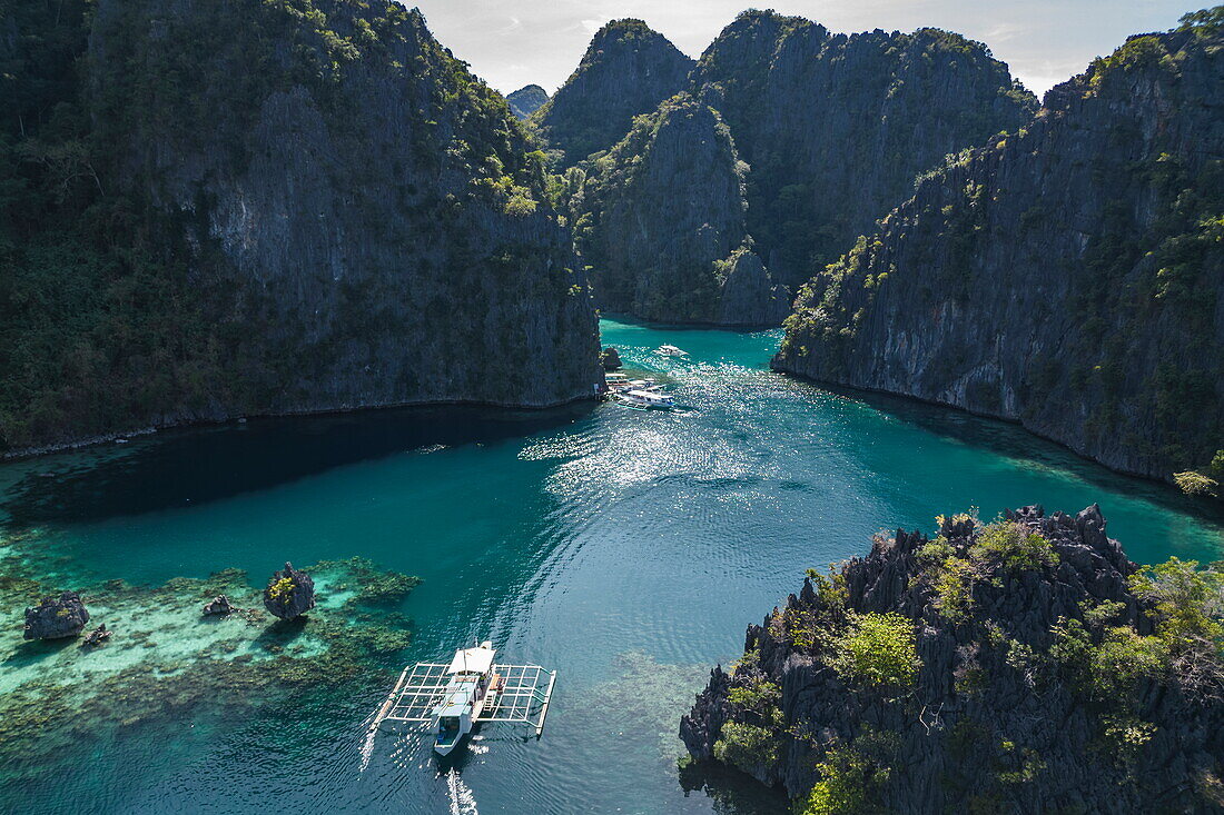  Aerial view of Bangka outrigger canoe tour boats moored in the lagoon near Kayangan Lake, Coron, Palawan, Philippines 