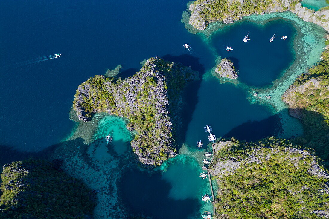  Aerial view of Bangka outrigger canoe tour boats moored in the lagoon near Kayangan Lake, Coron, Palawan, Philippines 