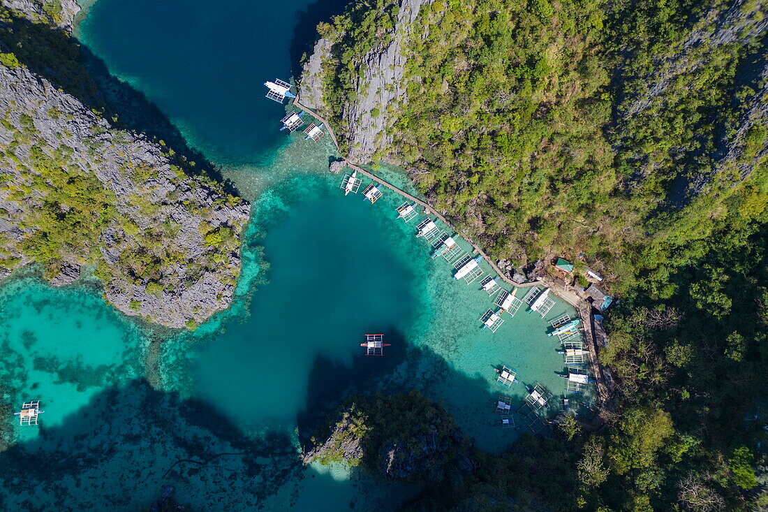  Aerial view of Bangka outrigger canoe tour boats moored in the lagoon near Kayangan Lake, Coron, Palawan, Philippines 