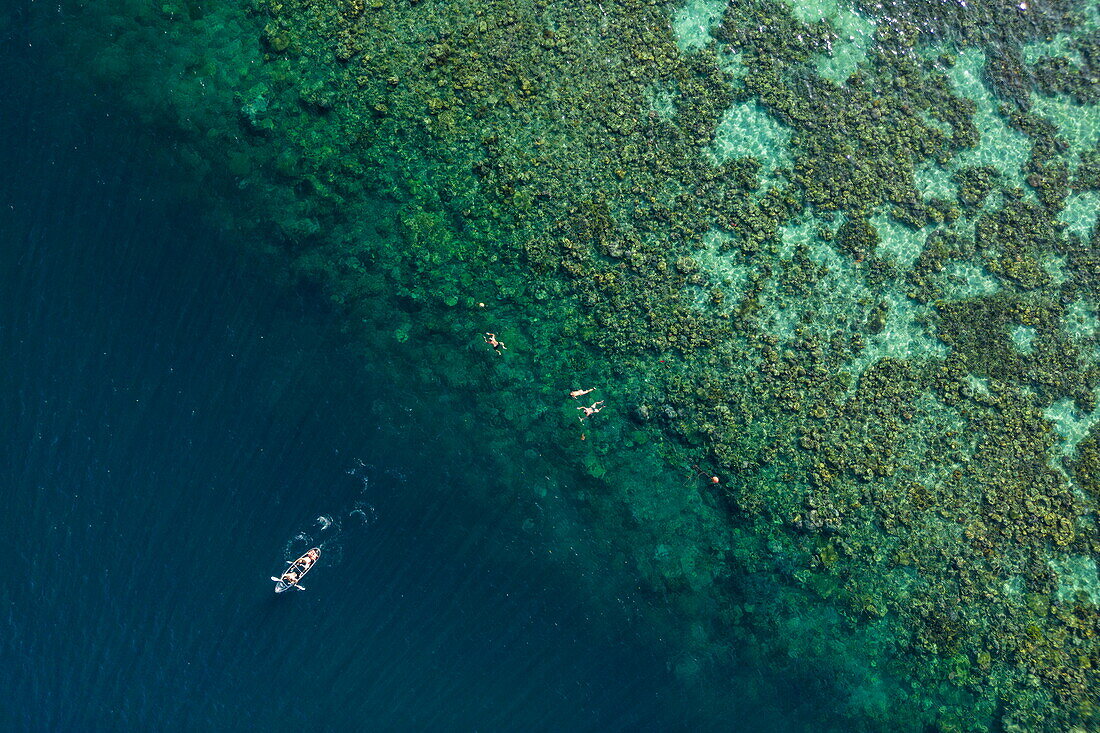 Luftaufnahme von Ruderboot und Menschen beim Schnorcheln, Riff von Siete Pecados, Sieben kleine Inseln, Coron, Palawan, Philippinen, Indonesien