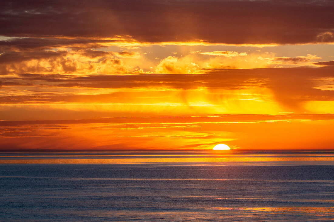 Sonnenuntergang am Meer mit Sonne und Wolken