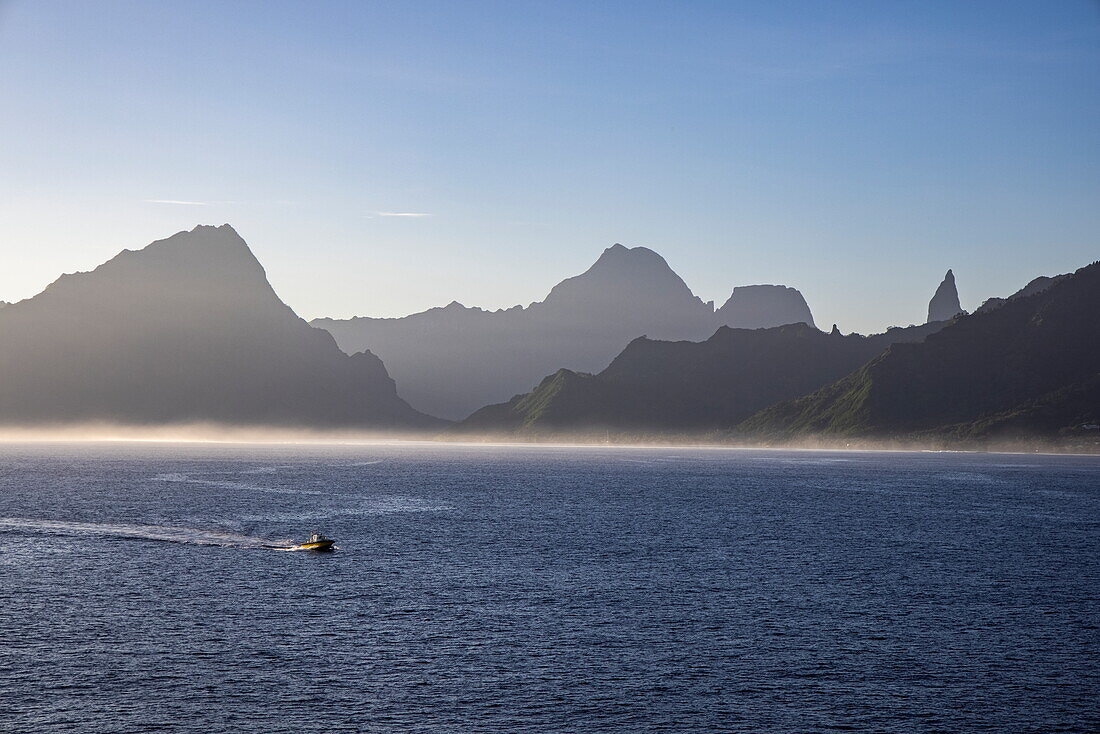  Boat and silhouette of mountains and morning mist, Moorea, Windward Islands, French Polynesia, South Pacific 