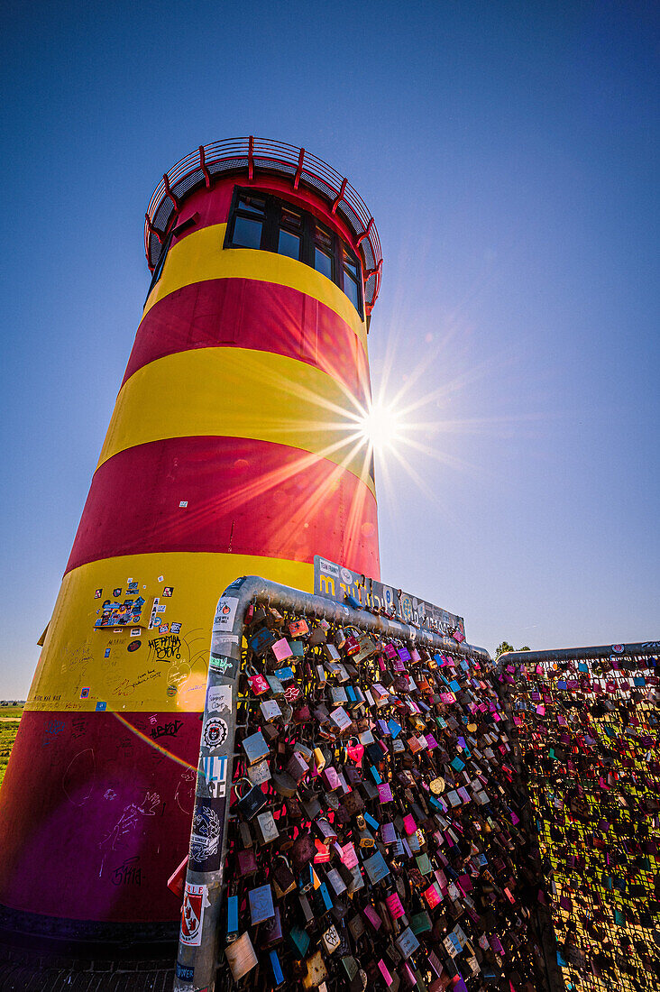 Der Pilsumer Leuchtturm auf dem Nordseedeich im Sommer mit blauem Himmel in der Nähe von Greetsiel, Gemeinde Krummhörn, Niedersachsen, Deutschland