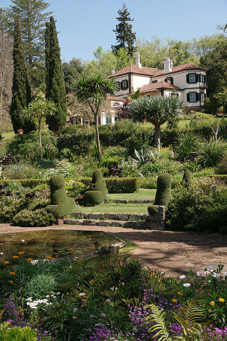 Jardines Palheiro, Staudenbeete, Teich und Wohnhaus zwischen Zypressen, Madeira, Portugal, Europa