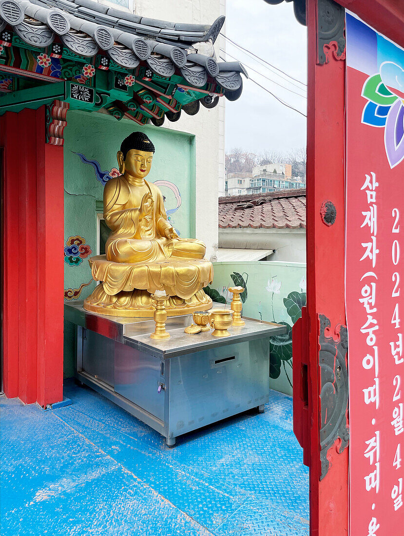  Golden Buddha statue in front of a temple, altar offerings, pagoda roof, downtown Seoul, South Korea, Asia 