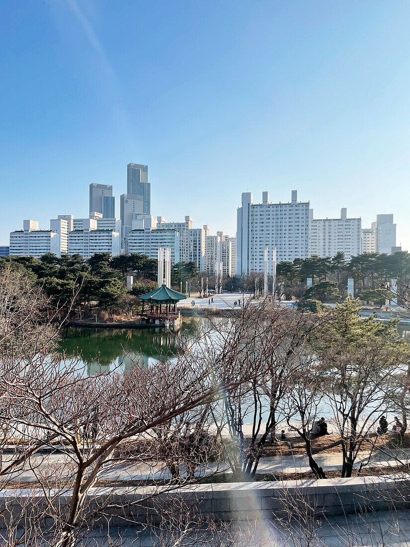  Lake in front of the National Museum, pagoda pavilion and urban skyscraper backdrop in winter sun, Seoul, South Korea, Asia 
