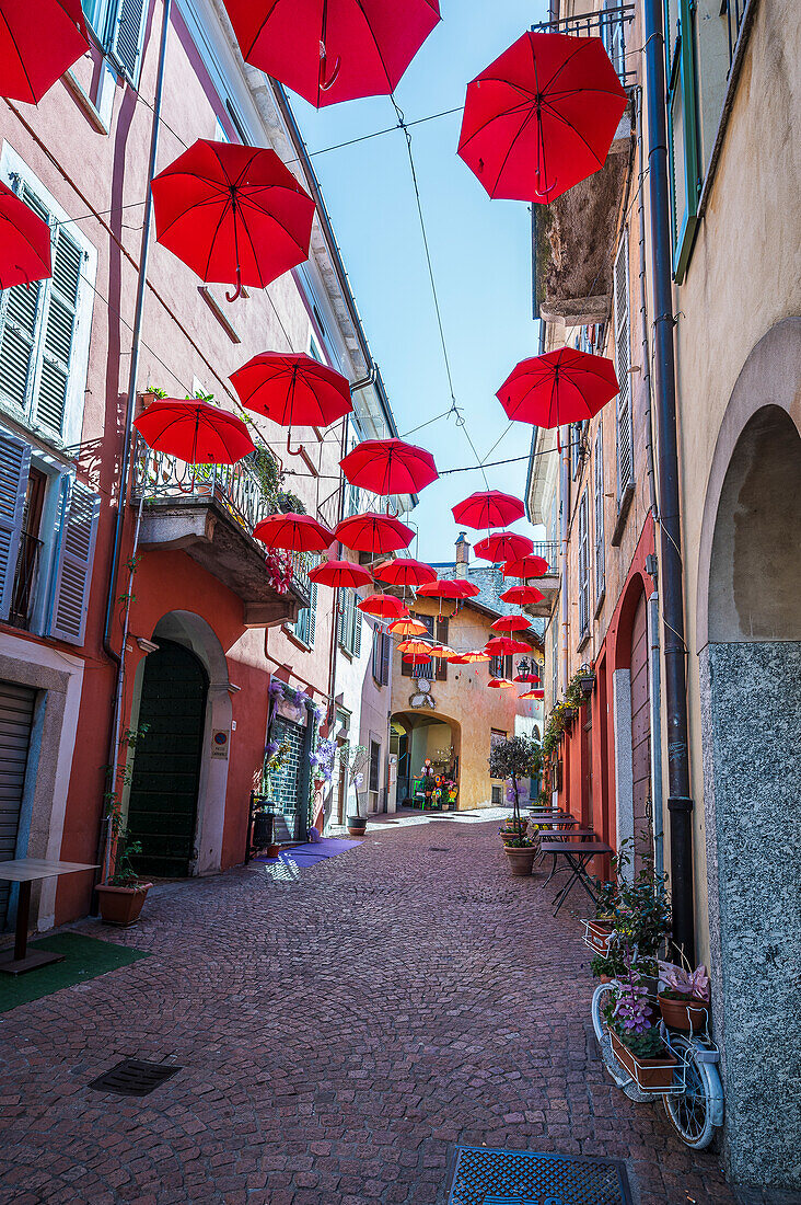  Red umbrellas in the old town of Luino, Varese province, Lake Maggiore, Lombardy, Italy, Europe 