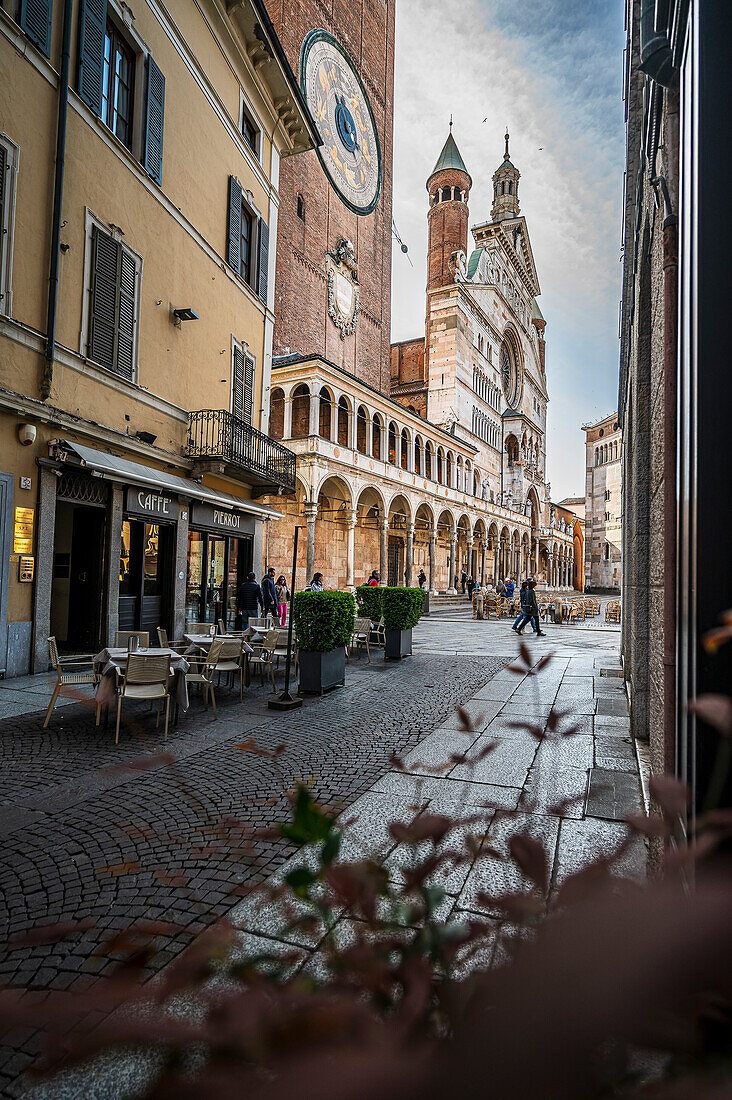 Strassencafe mit Stühlen in Gasse mit Glockenturm und Dom, Cremona, Provinz Cremona, Lombardei, Italien, Europa