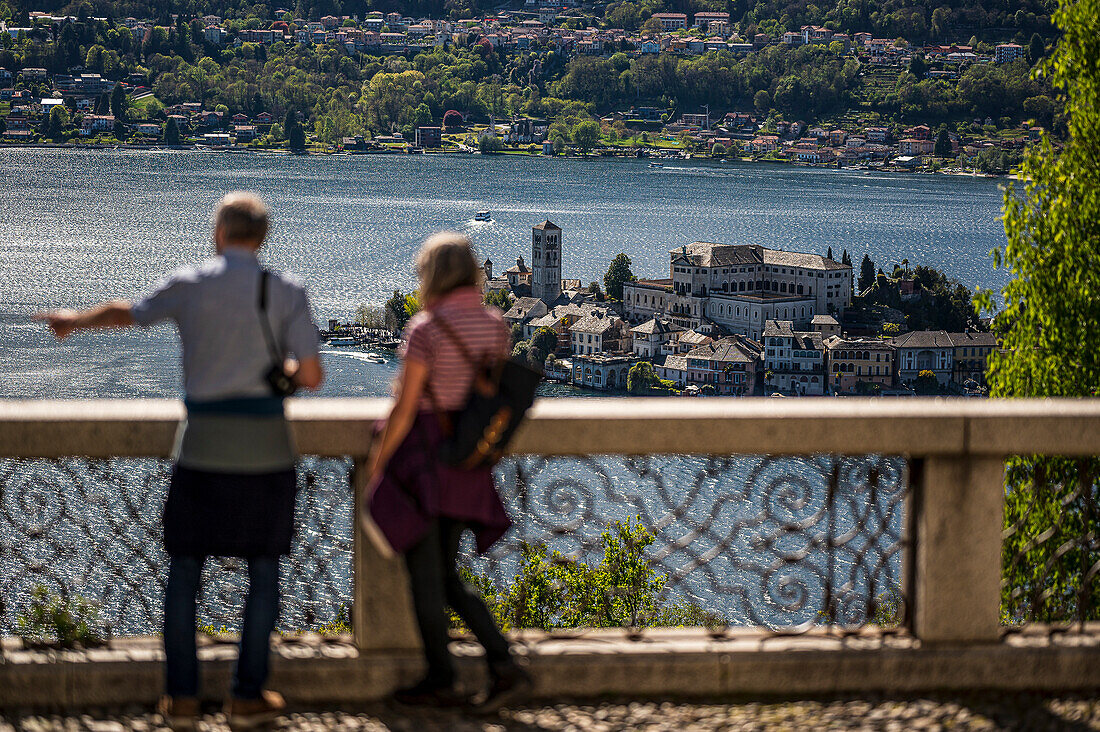 Menschen schauen auf See, Blick auf Insel Isola San Giulio, Gemeinde Orta San Giulio, Ortasee Lago d’Orta, Provinz Novara, Region Piemont, Italien