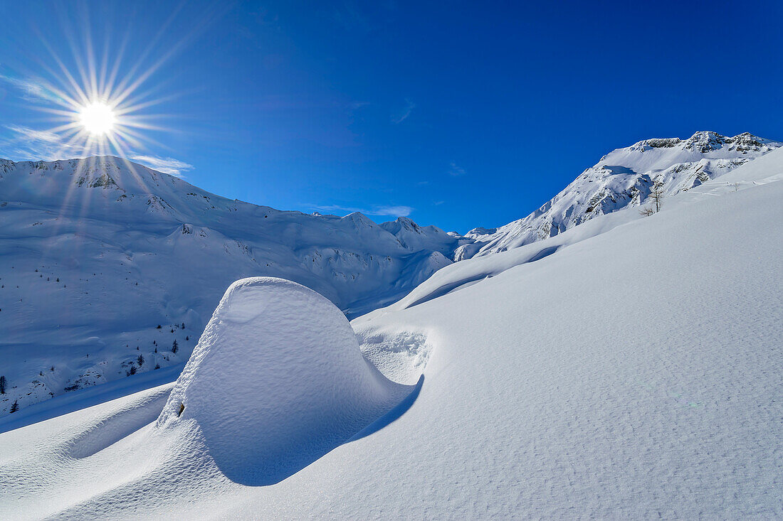 Verschneiter Felsen mit Pluderling im Hintergrund, Junsjoch, Tuxer Alpen, Tirol, Österreich