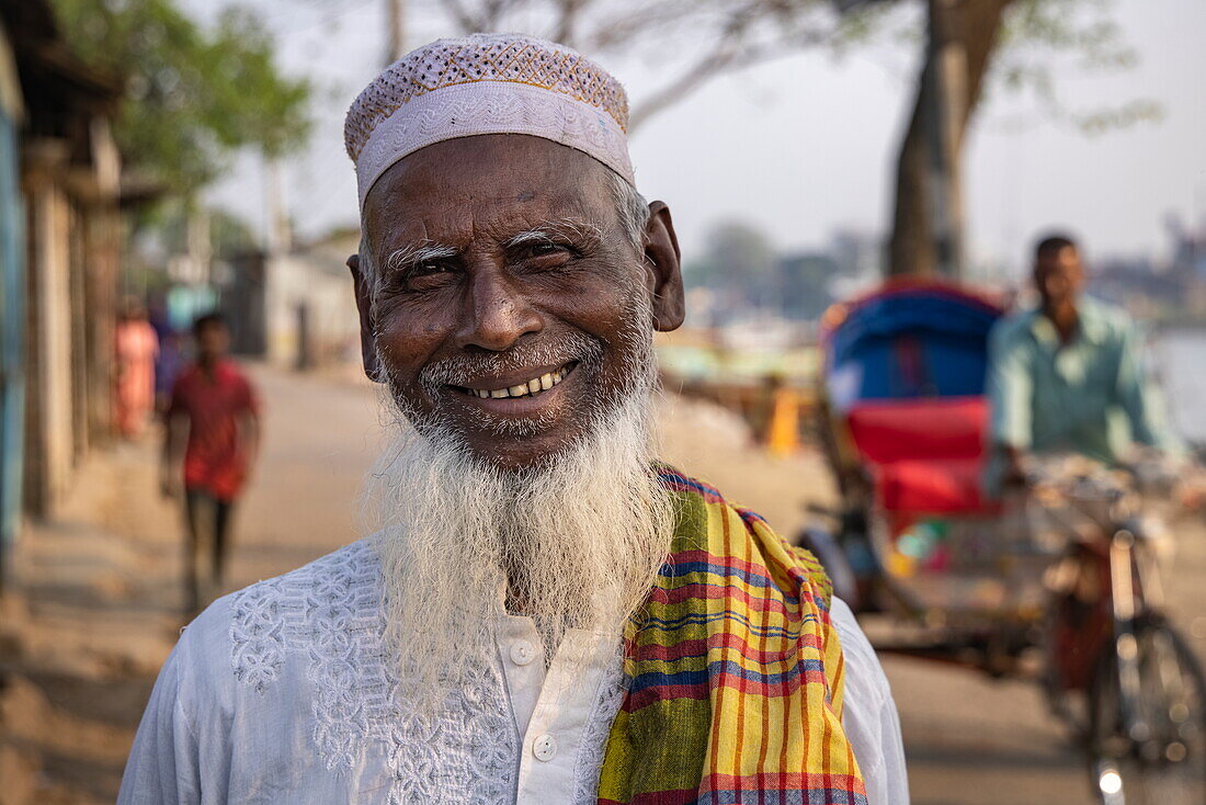  Portrait of smiling man with white beard and cycle rickshaw behind, Chandpur, Chandpur District, Bangladesh, Asia 