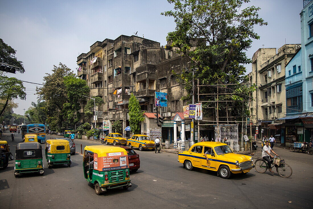  Tuk Tuks and traditional yellow taxis on a street in downtown Kolkata, Kolkata, India, Asia 