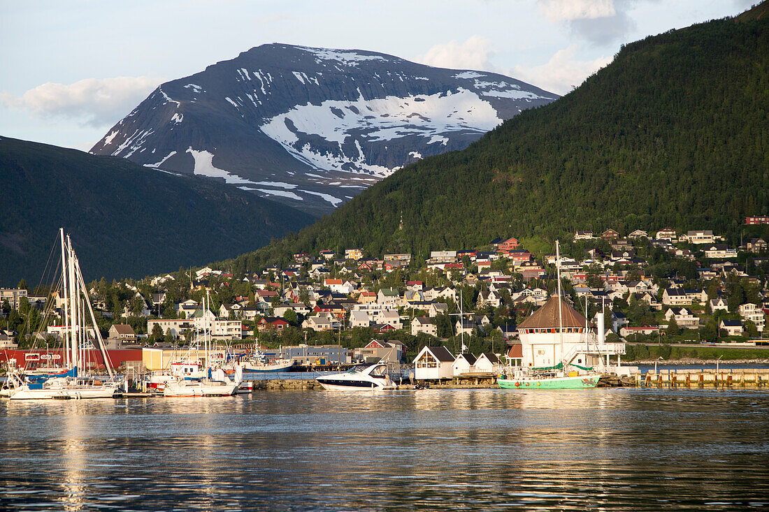 Suburban housing and landscape of snow on mountain side, Tromso, Norway warm evening light