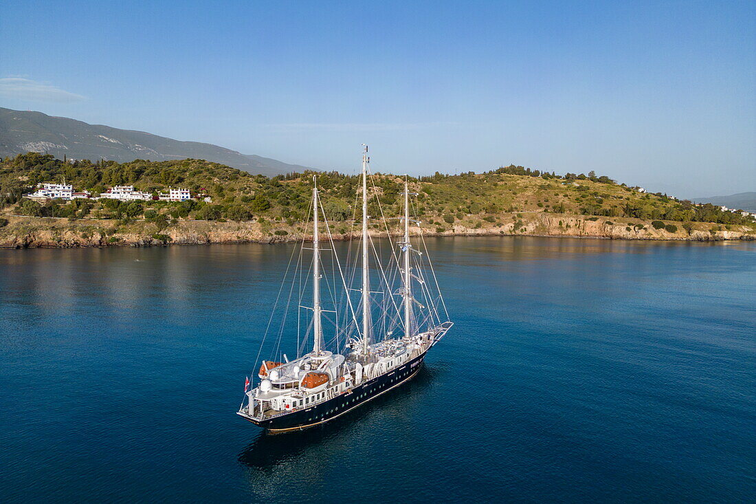  Aerial view of sailing cruise ship &quot;Running on Waves&quot; (M&#39;Ocean) anchored in a bay with coastline, Poros, Attica, Greece, Europe 