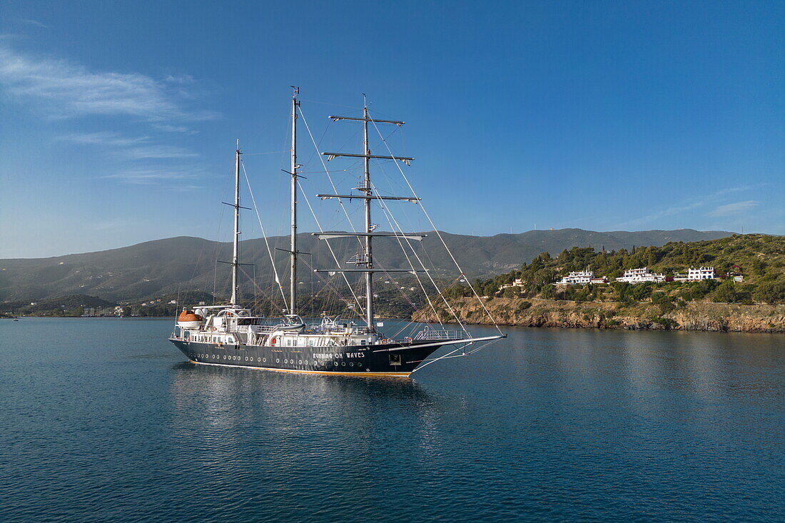  Aerial view of sailing cruise ship &quot;Running on Waves&quot; (M&#39;Ocean) anchored in a bay with coastline, Poros, Attica, Greece, Europe 