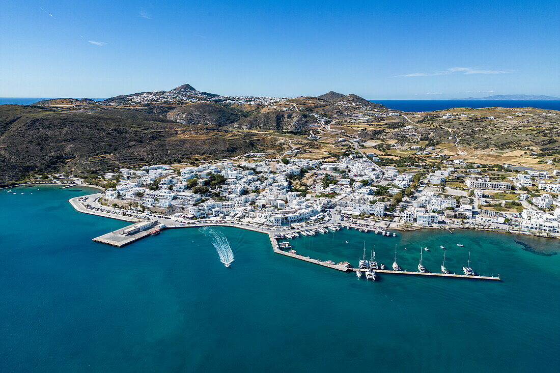  Aerial view of a dinghy from sailing cruise ship Running on Waves (M&#39;Ocean) leaving the harbour with town behind, Adamas, Milos, South Aegean, Greece, Europe 