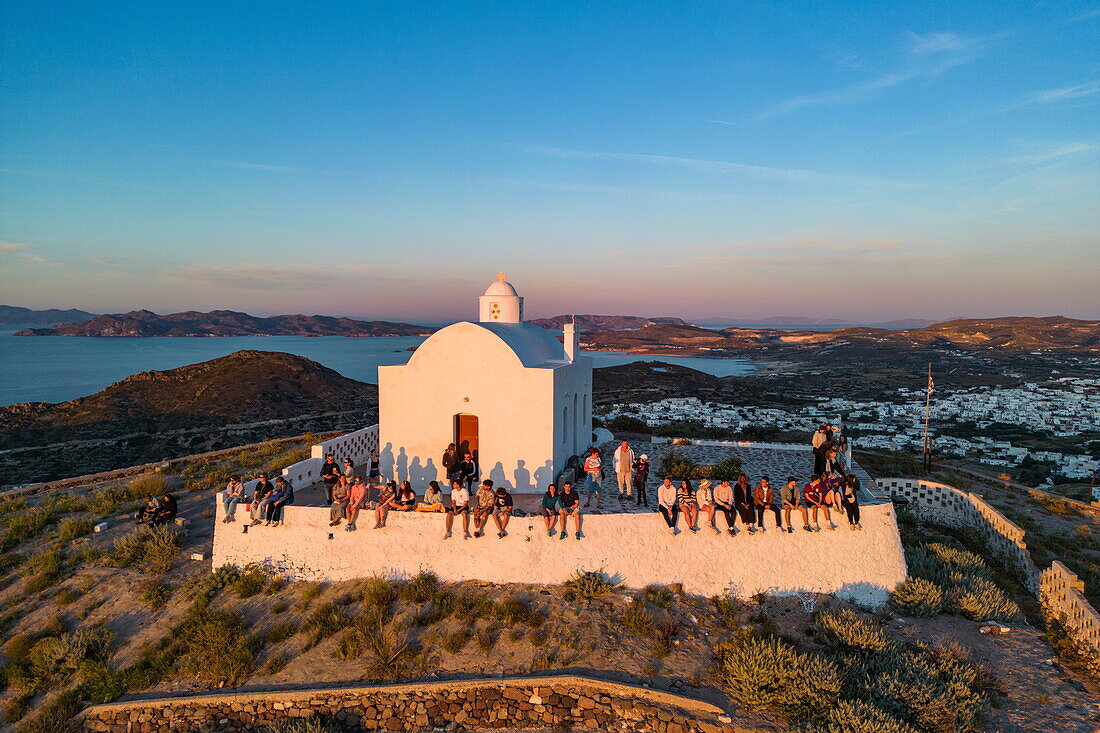  Aerial view of people enjoying the sunset from Panagia Church at Plaka Castle, Plaka, Milos, South Aegean, Greece, Europe 