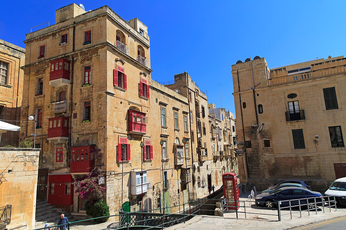 Red telephone box booth in historic city centre of Valletta, Malta