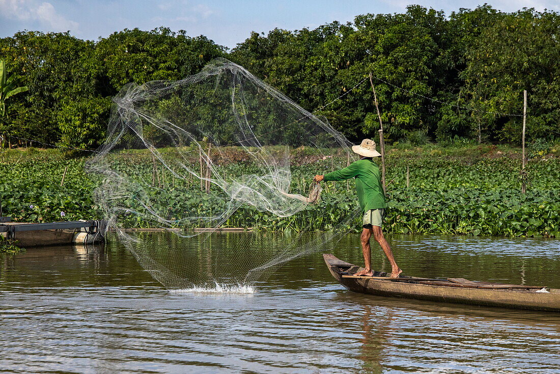 Fischer wirft Fischernetz von Boot, in einem Seitenarm des Mekong, Cao Lanh (Cao Lãnh), Dong Thap (Đồng Tháp), Vietnam, Asien