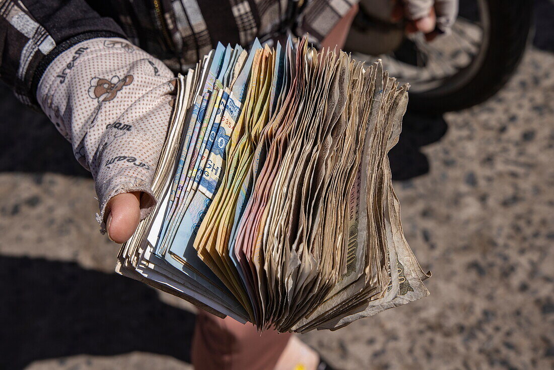 Hand hält große Menge vietnamesischer Dong-Banknoten, Tan Chau (Tân Châu), An Giang, Vietnam, Asien