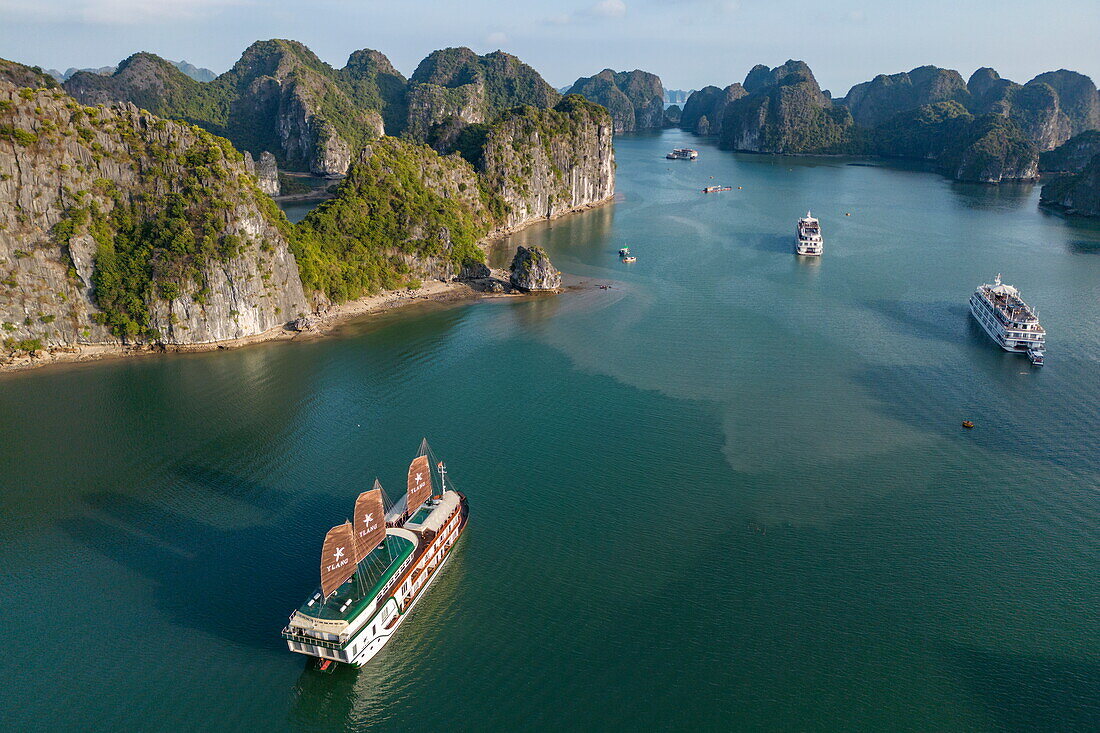  Aerial view of cruise ship Ylang (Heritage Line) with full sails in a bay surrounded by karst islands, Lan Ha Bay, Haiphong, Vietnam, Asia 