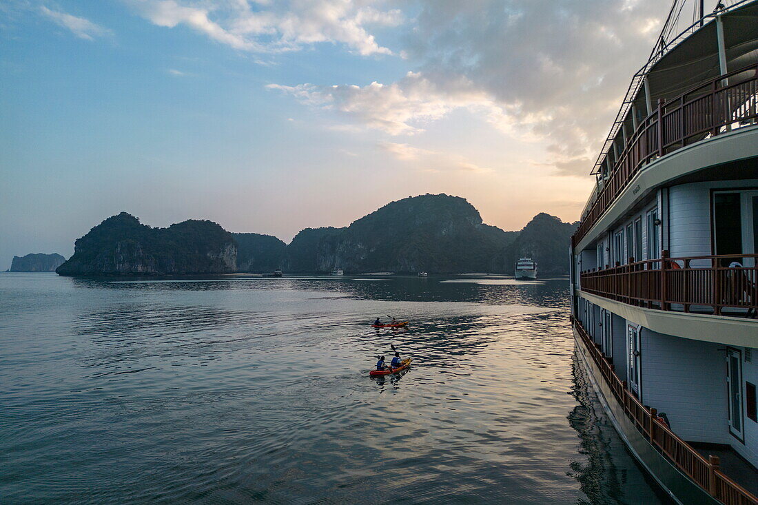 Kreuzfahrtschiff Ylang (Heritage Line) mit Seekajak bei Sonnenuntergang, Lan Ha Bay, Haiphong, Südchinesisches Meer, Vietnam, Asien