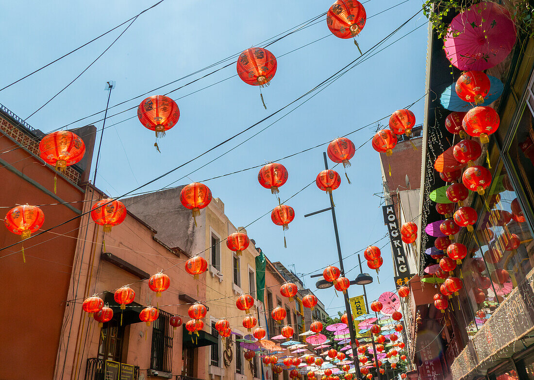 Rote chinesische Papierlaternen und Schirme hängen über der Straße in Chinatown, Mexiko-Stadt, Mexiko