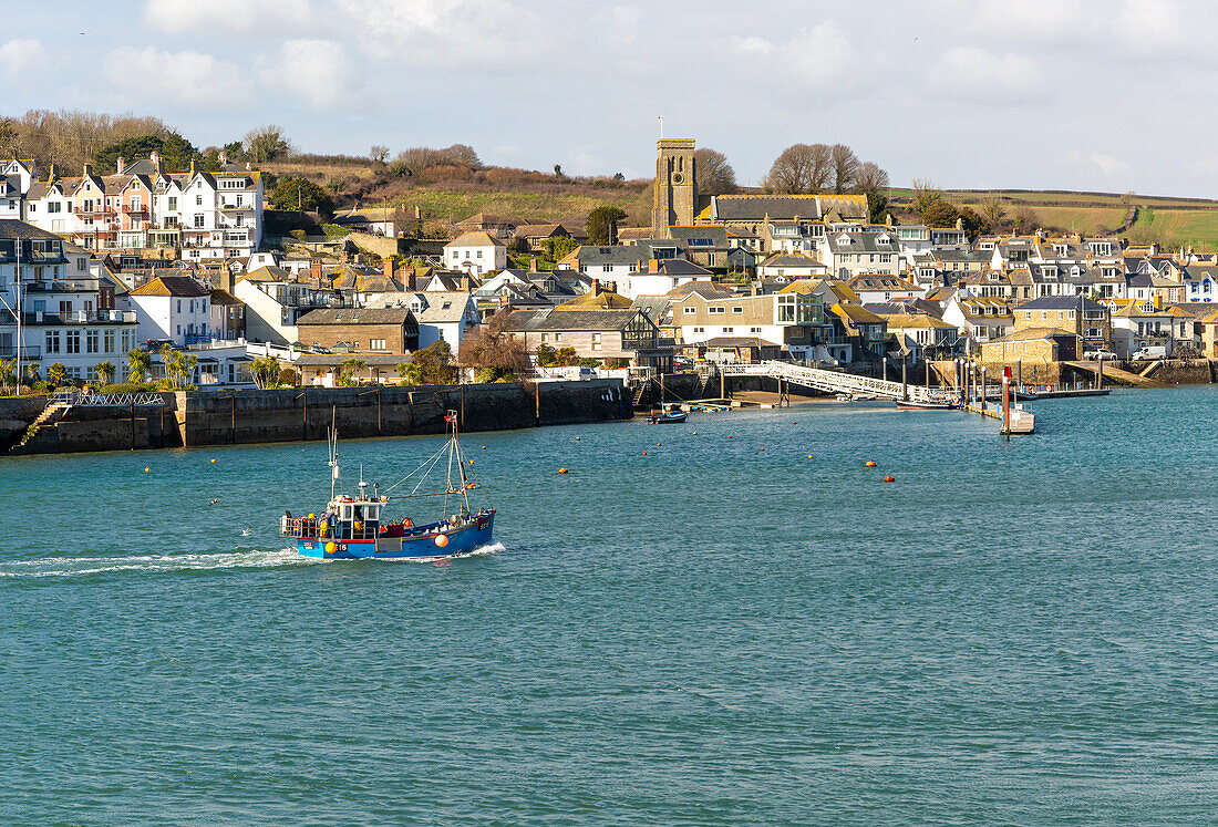 View of fishing boat returning to port, Salcombe, Devon, England, UK from across the estuary