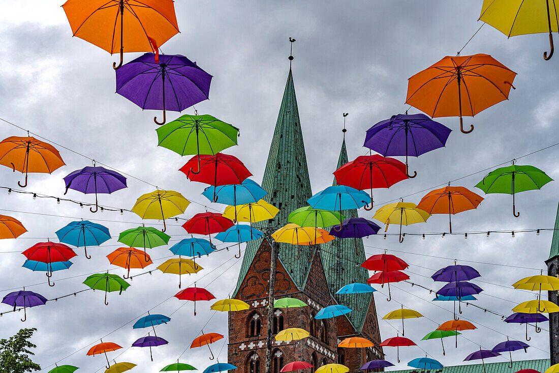  Colorful umbrellas at the HanseKulturFestival and the towers of St. Mary&#39;s Church, Hanseatic City of Lübeck, Schleswig-Holstein, Germany  