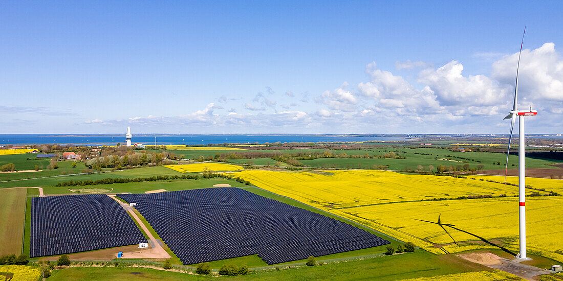  View of a PV area and a wind turbine with the Baltic Sea in the background, Ostholstein, Schleswig-Holstein, Germany 