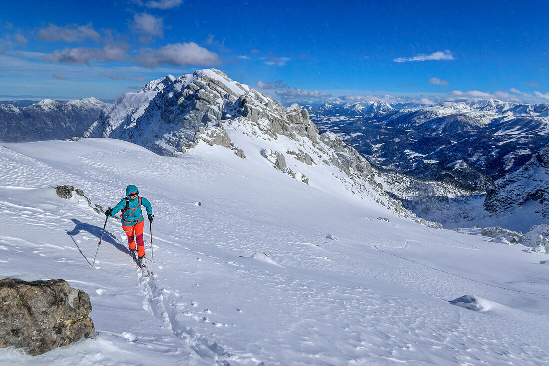  Woman on ski tour ascending through Kirtagskar to Arzlochscharte, Kirtagmauer in the background, Arzlochscharte, Totes Gebirge, Upper Austria, Austria 