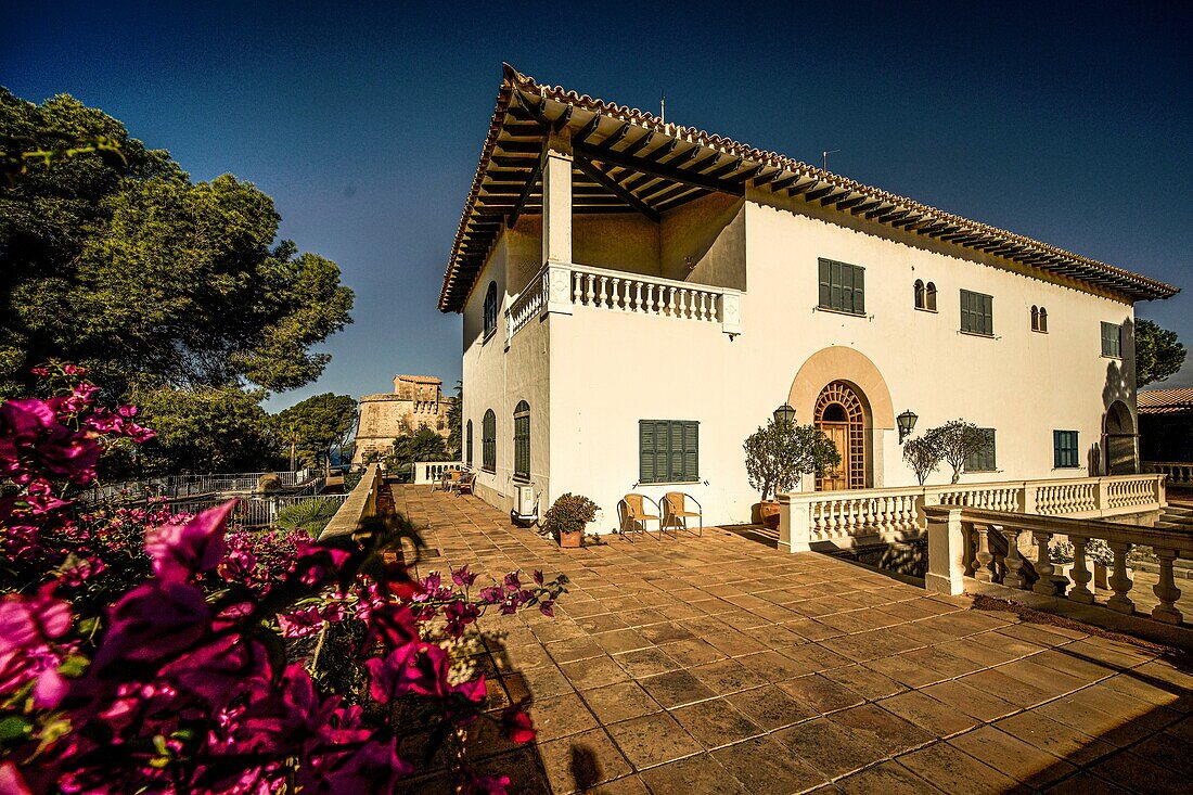  Mallorcan villa in the garden of the Es Castellot retirement home in Santa Ponca, in the background the tower of the Punta d´es Castellot castle, Mallorca, Spain 