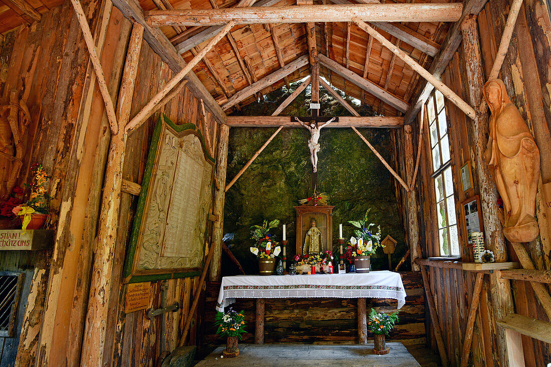  Interior of the forest chapel, also called the Peace Chapel of Sexten, built from wood on a rock. Sexten, Hochpustertal, South Tyrol, Italy 