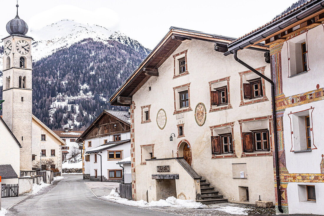 Traditionelle Häuser mit Sgraffiti an Fassade und Kirche, in Valchava, Winter, Graubünden, Schweiz