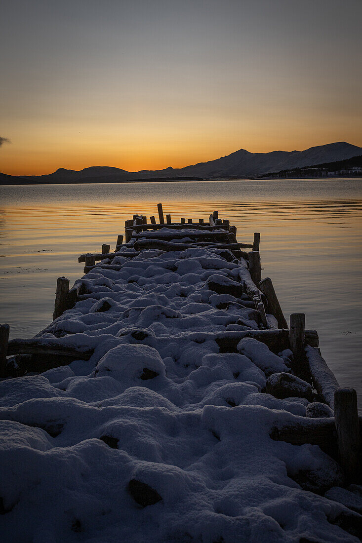 Winter in der Region Trömso, Kvaloysletta, Bucht mit altem Steg im Dämmerungslicht