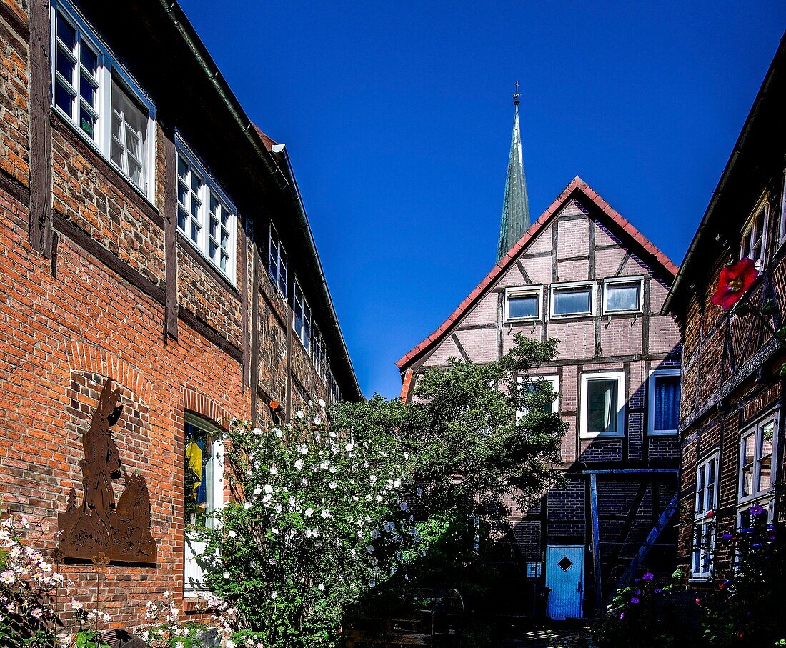  Figure hare and hedgehog, Hoyers Gang, former slum in the old town of Buxtehude, tower of the church of St. Petri in the background, Lower Saxony, Germany 