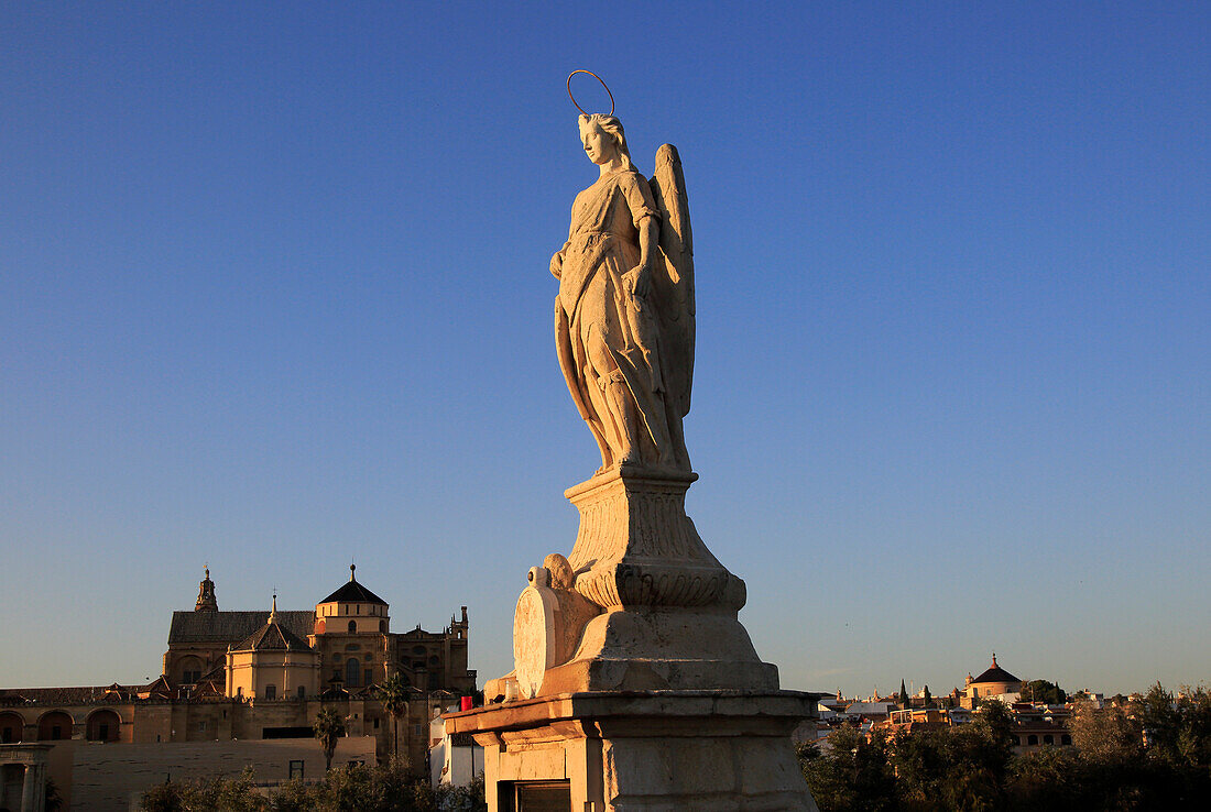 Angel San Rafael statue on Roman bridge  Cordoba, Spain with view towards the cathedral