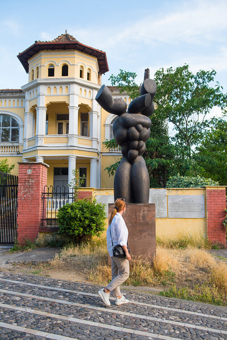 Contemporary sculpture in front of  an old building housing the Institute for Studies on the Crimes and Consequences of Communism (Iskk Albania), Tirana, Albania, Southeastern Europe