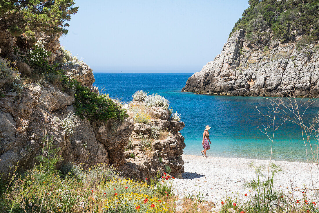  Frau spaziert am Strand der Dafines-Bucht, Halbinsel Karaburun, im Karaburun-Sazan-Meerespark, Bucht von Vlore, Albanien, Südosteuropa 