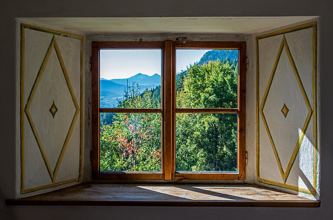 Blick aus dem Fenster aus altem Bauernhaus in die herbstliche Berglandschaft, Südtirol, Trentino, Italien