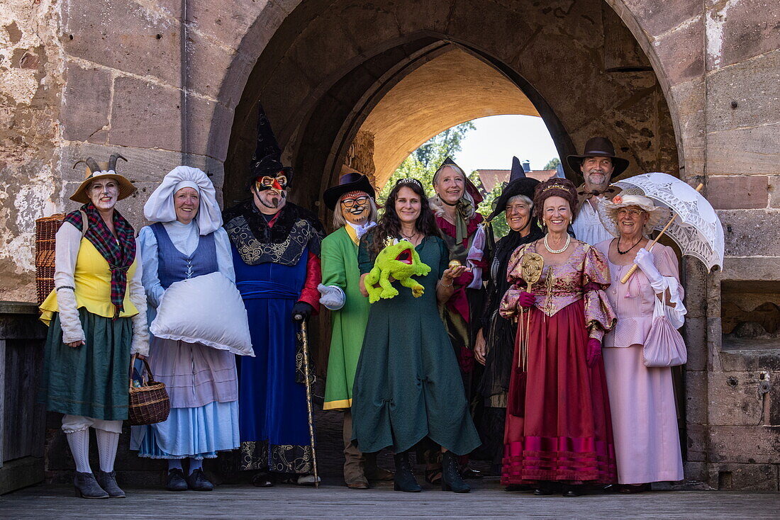  Locals in costumes of fairy tale characters from the Brothers Grimm pose in front of the gate to Steinau Castle, Steinau an der Straße, Spessart-Mainland, Hesse, Germany 