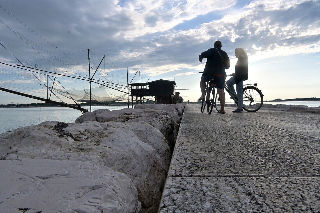 Fischerhäuser 'Casoni' an der Mole der Lagune an der Adria bei Sonnenuntergang, Sottomarina bei Chioggia, Adria, Veneto, Italien