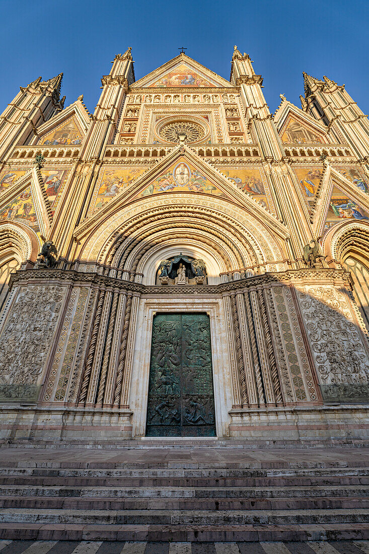 Vor dem Portal des Doms von Orvieto, Umbrien, Italien