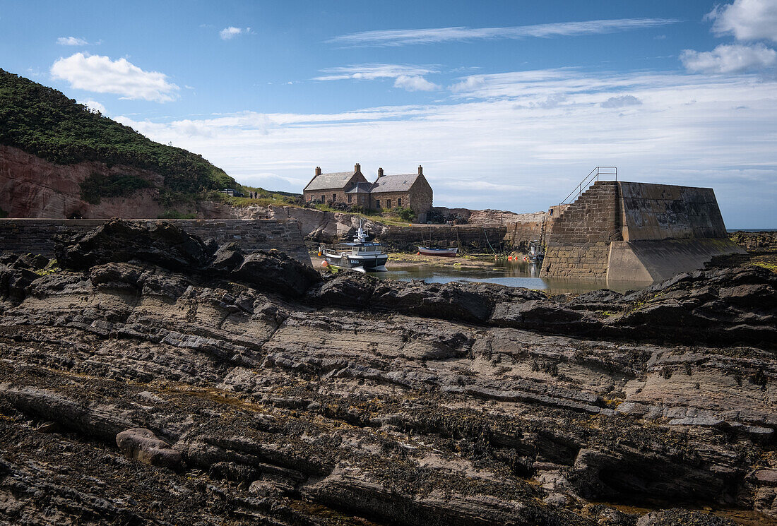  View of an old stone house in an old harbour at low tide, East Lothian, Scotland, United Kingdom 