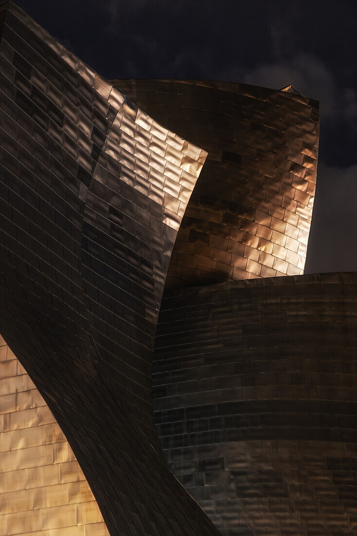  Guggenheim Museum from outside at night. Facade illuminated. Golden. Bilbao, Basque Country, Spain 